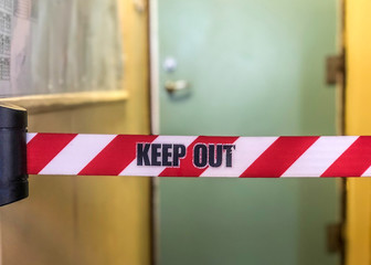 Concept of keeping unwanted persons from entering. Keep out sign a red and white prohibited to enter stripe and a door in the background in an industrial environment
