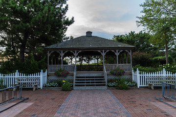 Garden Gazebo with White Picket Fence at Sunrise with Blue cloudy sky