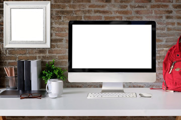Loft student workspace with blank screen desktop computer on white wood desk.