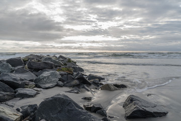 Rockwall in Ocean With Crashing Water at Sunrise Landscape