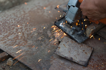 man cut out a sheet of iron, spark on a black background