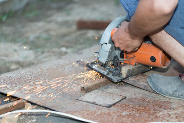 man cut out a sheet of iron, spark on a black background