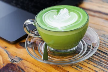 Photo sur Plexiglas Theé une tasse de thé vert au lait chaud sur la table
