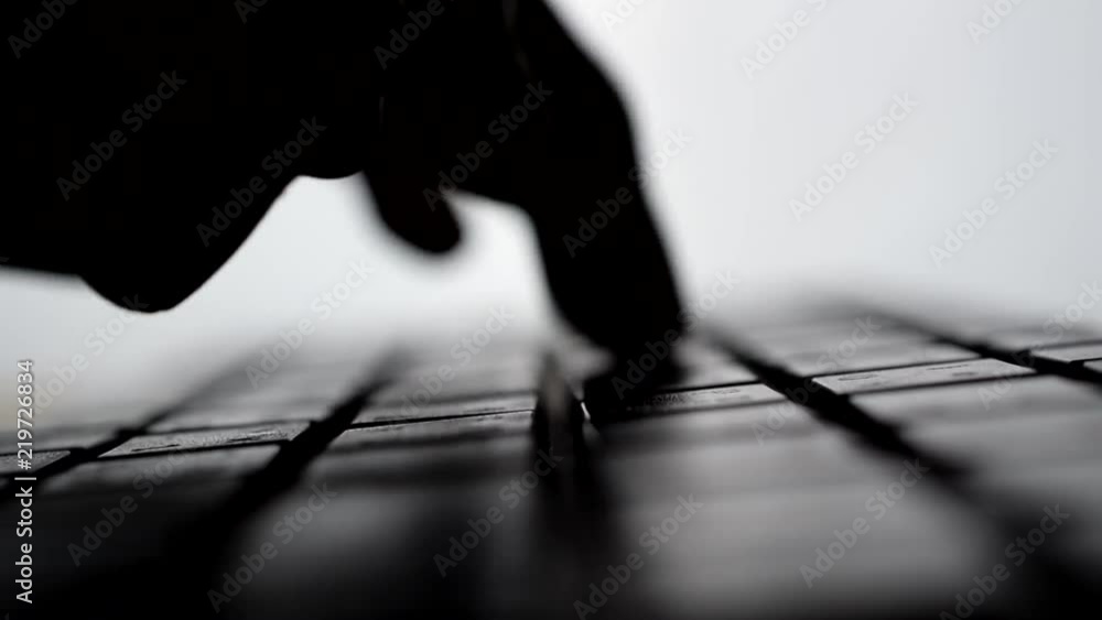 Poster Man typing on computer keyboard. backlit with shallow depth of field. Closeup