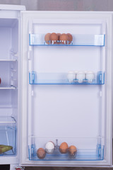Open fridge, eggs on the shelf of refrigerator door, healthy nutrition concept