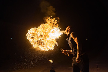 Fire show artist breathe fire in the dark