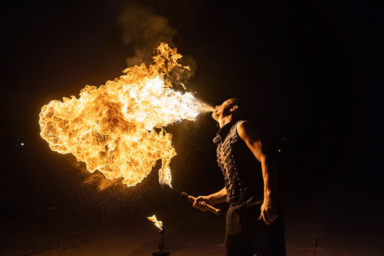 Fire show artist breathe fire in the dark