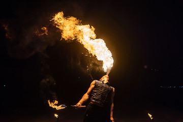 Fire show artist breathe fire in the dark