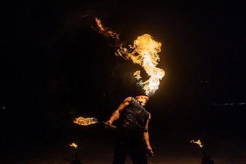 Fire show artist breathe fire in the dark