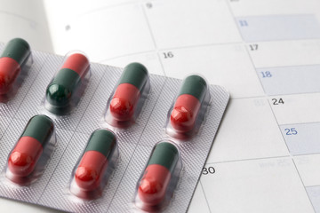 Close up pill with date of calendar background. Close up Medicine pills on calendar