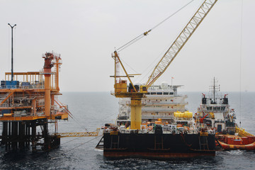 Fototapeta na wymiar Supply boat transfer cargo to oil and gas industry and moving cargo from the boat to the platform