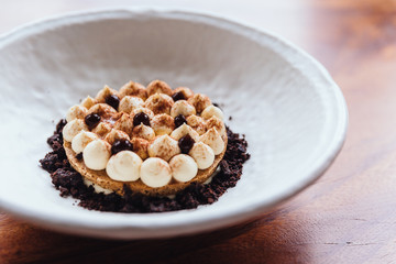 Creative dessert: Thin cream biscuit topping with cream, cocoa powder and chocolate crumble.  