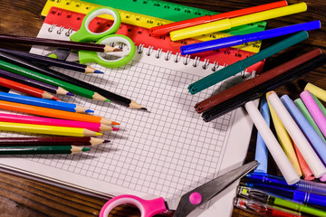 Different school stationeries on a dark wooden table