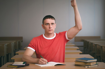 Student is raising his hand and wants to answer the teacher's question.