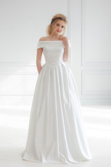 Fototapeta na wymiar beautiful bride in simple luxurious wedding dress. Full-lenght studio portrait