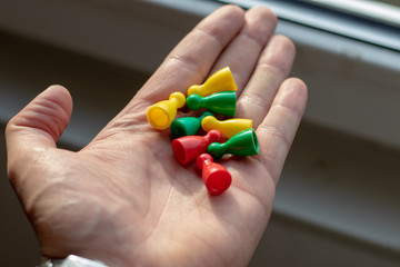 Group of colorful tokens in the hand of a man