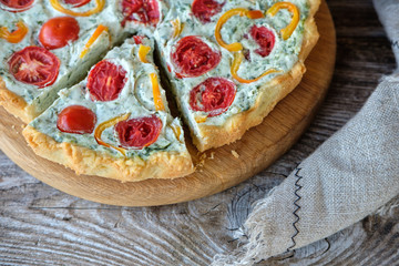 French quiche with tomatoes and pepper and broccoli on wooden Board