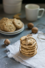 Oatmeal cookies tied with a rope on a white linen napkin and cookies on a plate in the background