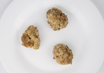 Fried homemade patties on a white plate.