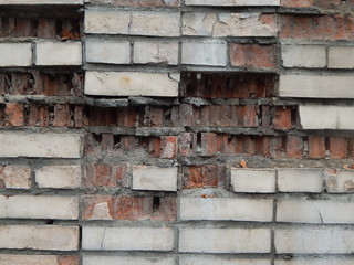 Old dilapidated wall with broken bricks