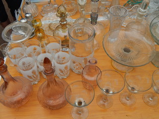 Selection of vintage glassware on the flea market: vases, glasses, salad bowls, wine glasses, wine glasses, candy bars