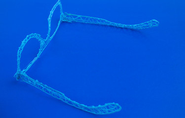 Glasses made with a 3d pen on a blue background.