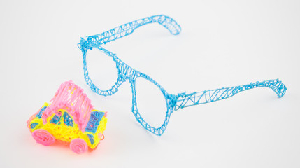 Glasses made with a 3d pen and a toy car on a white background.
