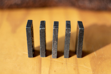 Some black dominos on a wooden tabke