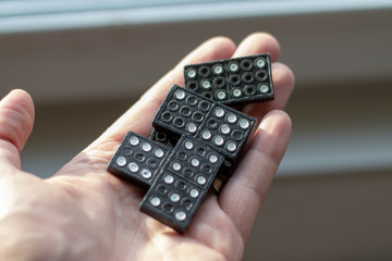 Black dominos lying in a human hand