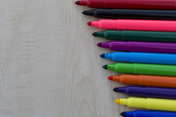 Fototapeta premium colorful felt-pens and clock on the wooden table for school or kindergarten activity time or education concept.creative ideas for child development.back to school concept.