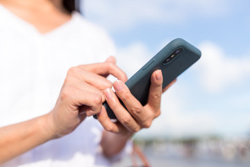 Asian woman use of mobile phone in city