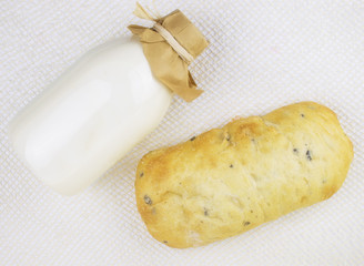 A bottle of eco milk and bread on a light background.