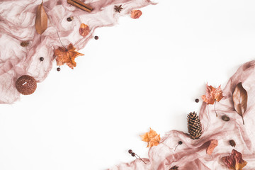 Autumn composition. Brown fabric, autumn flowers and leaves on white background. Flat lay, top view, copy space