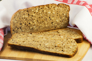 Sliced rye bread on cutting board. Whole grain rye bread with seeds. Delicious whole grain bread.