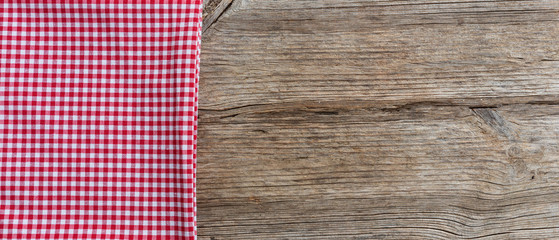 Red white checkered tablecloth on wooden table, banner, copy space