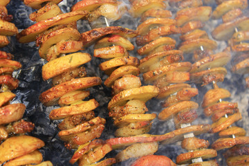 Shashliks from pieces of potatoes and bacon. Picnic at nature