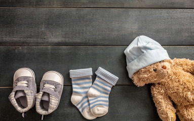Baby boy shoes and socks on blue wooden background
