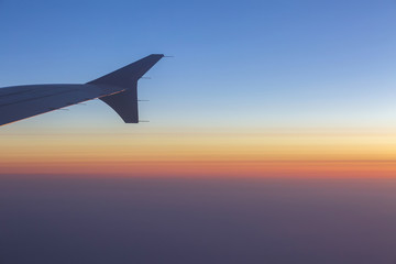Wing of an airplane in the sunset. Airplane wing out of window.