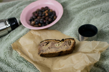 A piece of homemade cake and a thermos in the background.