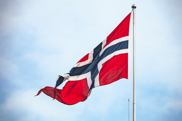 Flag of Norway waving over cloudy sky