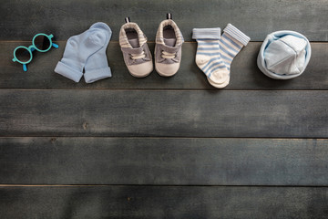 Baby boy clothes and accessories on blue wooden background