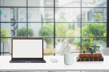 Loft workspace with mockup laptop on desk	