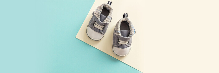 Baby boy shoes on pastel colors background, banner