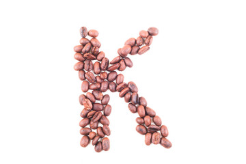 The alphabet K from roasted coffee beans. Isolated. White background.