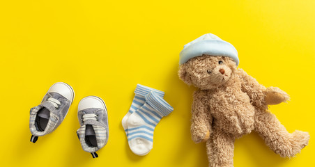 Baby boy shoes and socks on bright yellow background