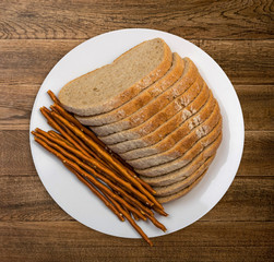 Slices of brown bread on white plate on wooden table