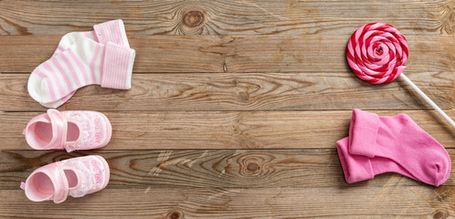 Baby girl shoes and socks on wooden background