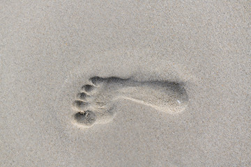 Fototapeta na wymiar Footprints walking on the beach by the morning, The concept of walking destination