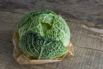 Fresh Savoy cabbage closeup on rustic wooden background. Isolated. Healthy food concept.