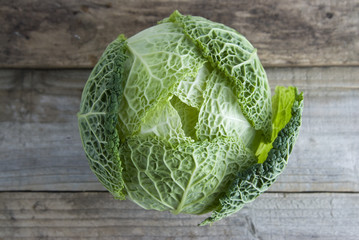 Fresh Savoy cabbage closeup on rustic wooden background. Isolated. Healthy food concept.